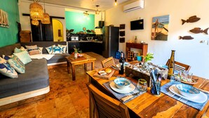 Un salon confortable avec un canapé, une table à manger et un coin cuisine.