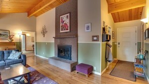 Un salon avec une cheminée, un canapé, une table basse et une bibliothèque.