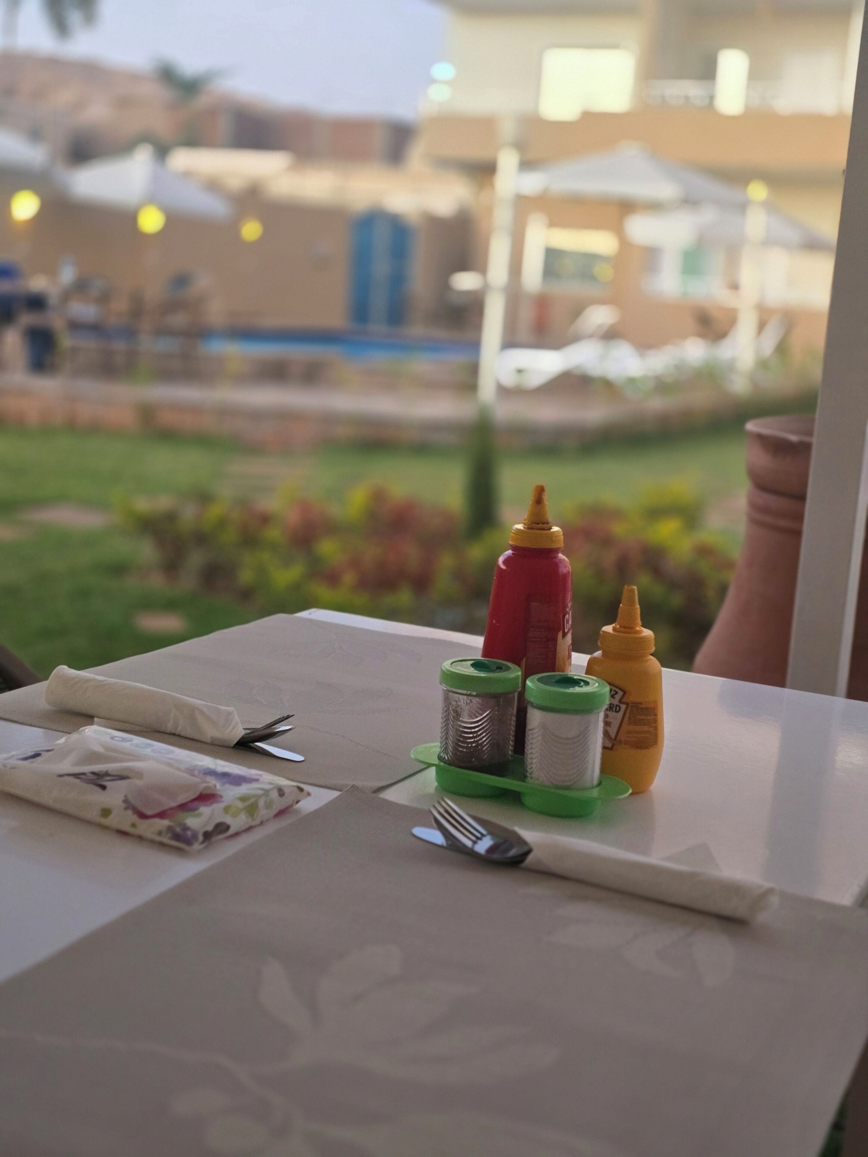 A table set with condiments, a napkin, and cutlery.