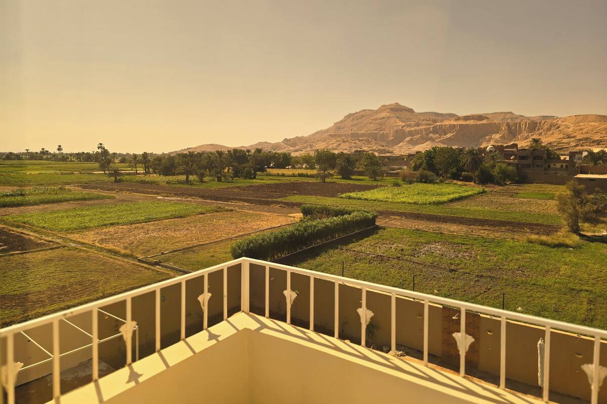 Un balcon offrant une vue sur des champs en terrasses et une montagne en arrière-plan.