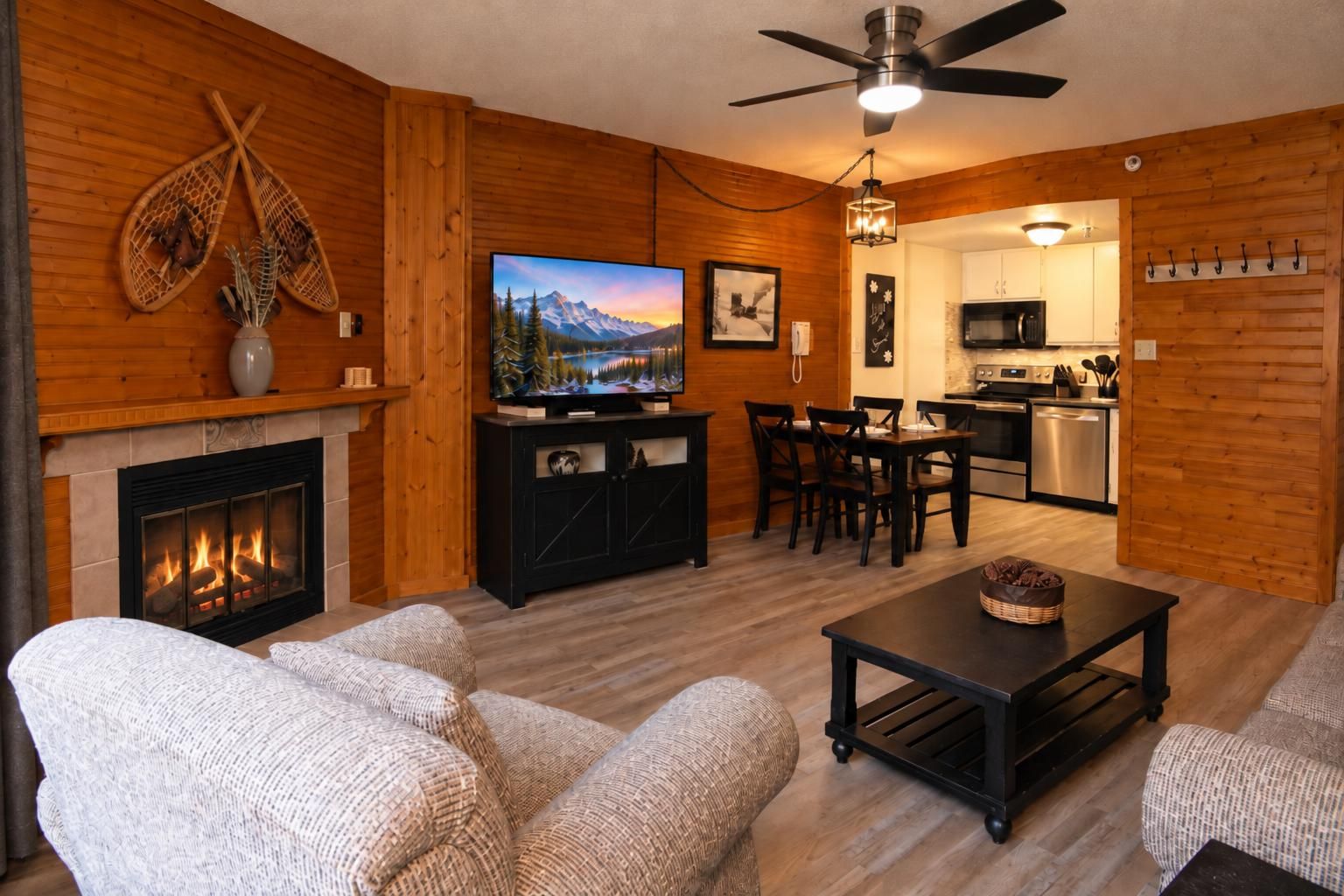 A cozy living room with a fireplace, a television, and a dining area.