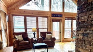 A cozy cabin interior with two leather sofas, a small table with a lamp, and a stone fireplace. - Mountain top cabin with big views, a relaxing hot tub and 2 gas fireplaces. (Ellijay)