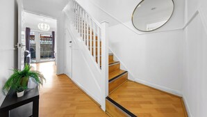 A staircase with white railings and a wooden finish, leading to an upper floor. - Cozylease 3-Bed Retreat Near O2/LCY with Gym, Workspace, Garden & Free Parking (London)