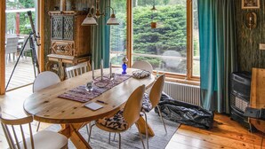 A dining area with a wooden table, chairs, and a view of greenery outside. - Beautiful home in Muskö with WiFi (Muskö)