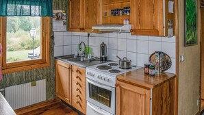 A kitchen with wooden cabinets, a stove, and a sink. - Beautiful home in Muskö with WiFi (Muskö)