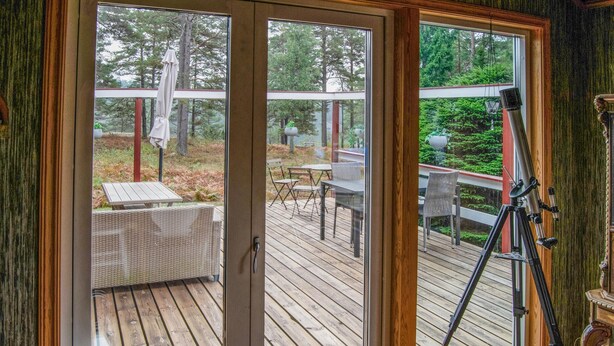 A wooden deck with outdoor furniture and a telescope. - Beautiful home in Muskö with WiFi (Muskö)