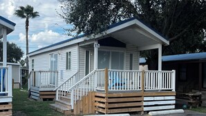A mobile home with a wooden deck and a covered porch.
