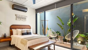 Un dormitorio moderno con una cama de madera, un banco y un ventilador de techo.