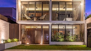 Un edificio moderno de varios pisos con amplios ventanales y balcones, que ofrece tanto zonas de estar interiores como exteriores.