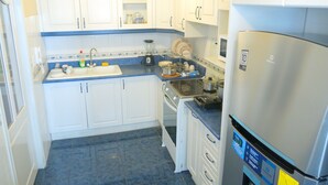 A kitchen with white cabinets, a stainless steel refrigerator, and a dishwasher. - Spacious 3-bedroom apartment in lovely Quito with WiFi (Quito)