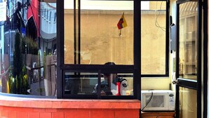 A corner kitchen with a microwave on a wooden cabinet, a refrigerator, and a window with a view of the street. - Spacious 3-bedroom apartment in lovely Quito with WiFi (Quito)