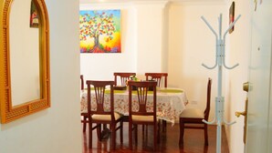 A hallway leading to a dining area with wooden flooring, a patterned rug, and a coat rack. - Spacious 3-bedroom apartment in lovely Quito with WiFi (Quito)