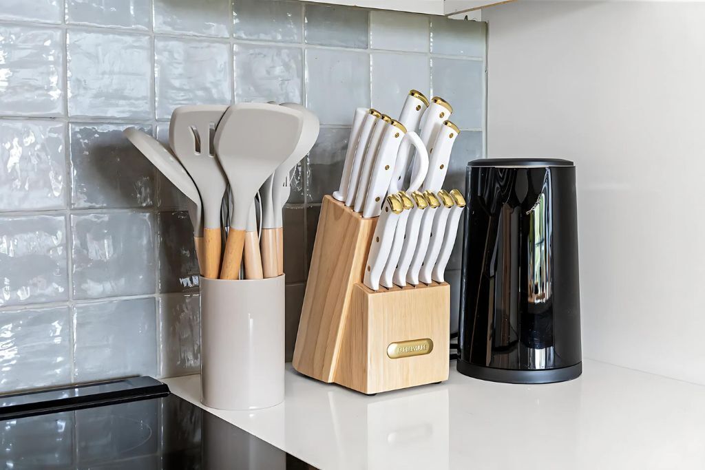 Eine Küchenarbeitsplatte mit Messerblock, Kaffeemaschine und Pfannenwender.