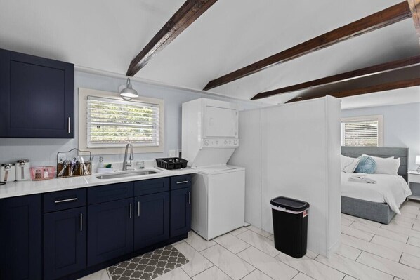 A compact kitchen with a sink, cabinets, and a window. - Stylish Studio in B&B Locale (Gainesville)