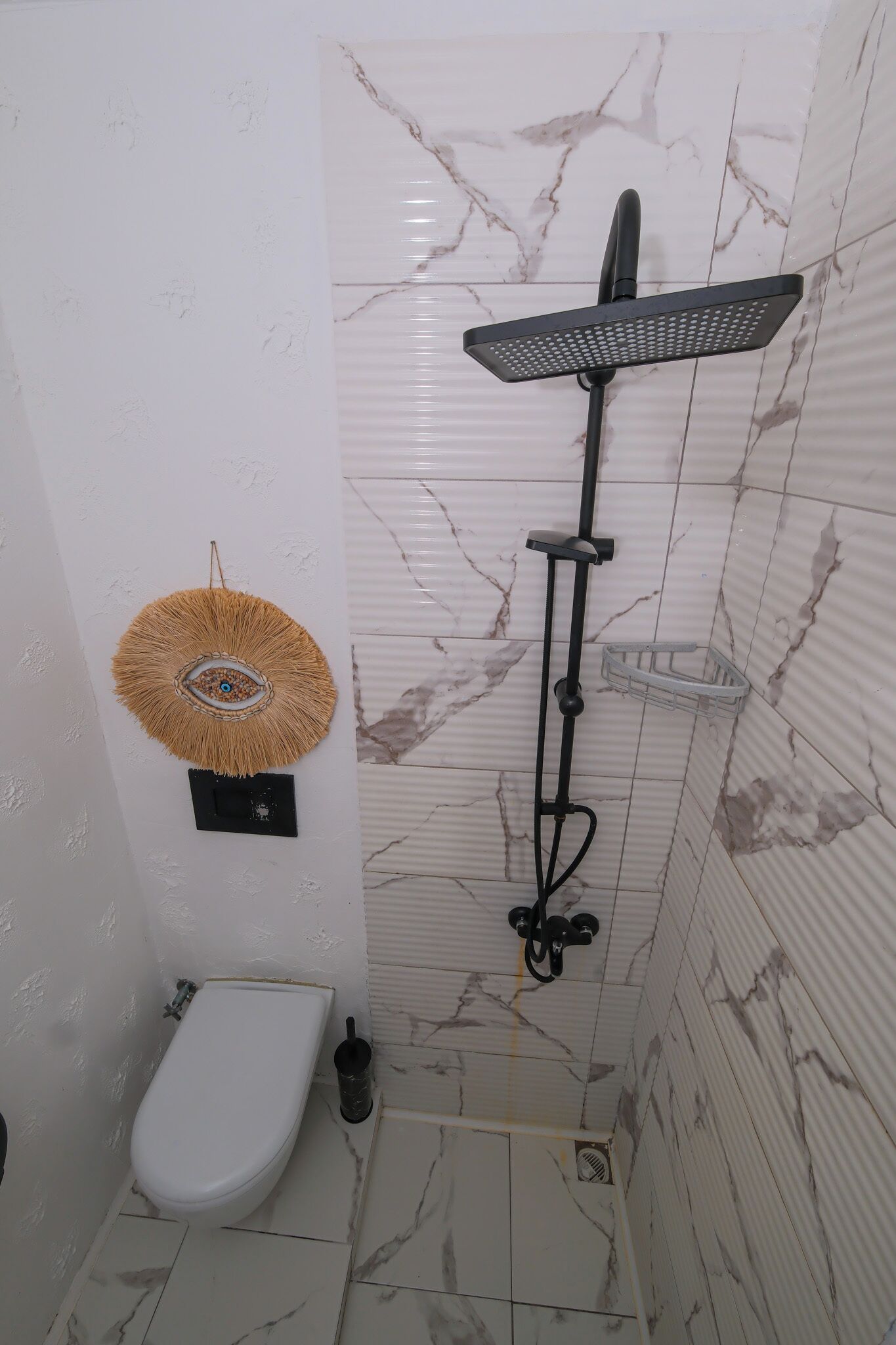 A bathroom with a shower, toilet, and decorative wall art.