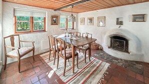 A dining room with a wooden table and chairs, a fireplace, and framed pictures on the wall. - 2 bedroom beautiful home in Glemmingbro (Glemmingbro)