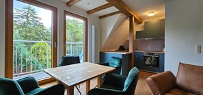 Una cocina moderna con horno empotrado y comedor con mesa y sillas de madera.