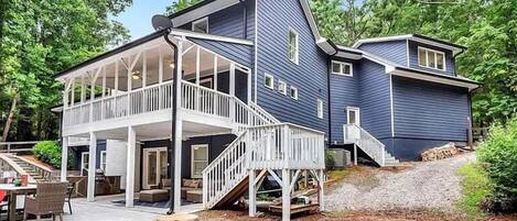 A two-story house with a balcony and a covered patio area.