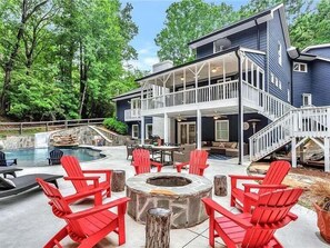 A two-story house with a covered patio, outdoor seating, and a swimming pool. - Georgia Lakeside Getaway w/ Private Pool (Flowery Branch)