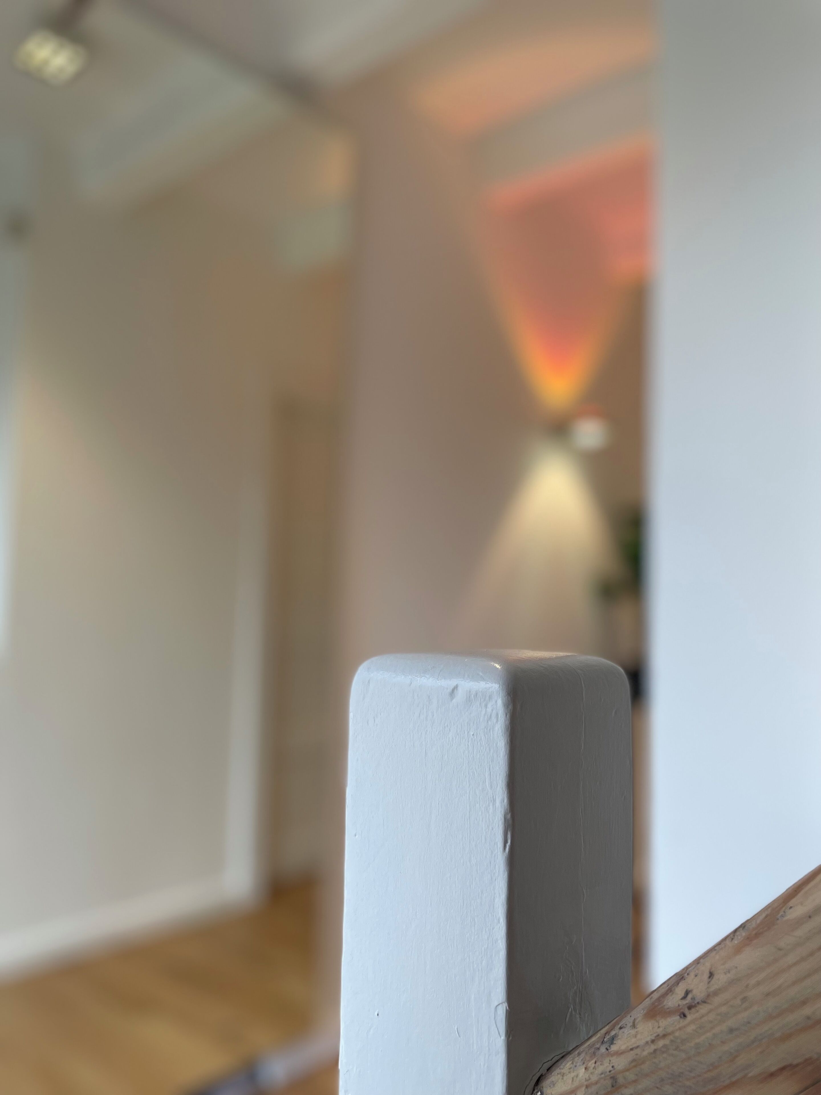 A close-up of a white-painted wooden railing with a smooth finish.