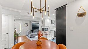 Een moderne keuken met witte kasten, een zwarte koelkast en een magnetron.
