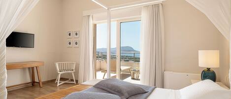 A bedroom with a bed, a desk, a chair, a TV, and a balcony with a view.