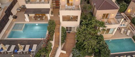 Un complexe résidentiel moderne doté d’une piscine centrale, de nombreux balcons et d’espaces de détente extérieurs.