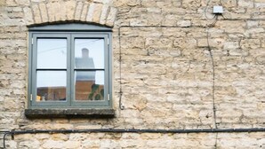A stone building with two windows and a door, each with green shutters. - The Honey Stone Townhouse, Trendy Townhouse in Chipping Norton (Chipping Norton)