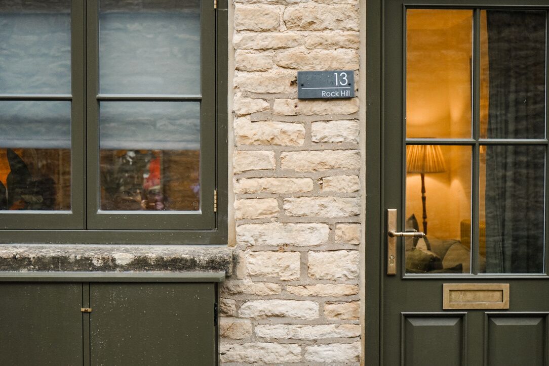 A building with a stone wall and a door labeled "13 Rock Hill."