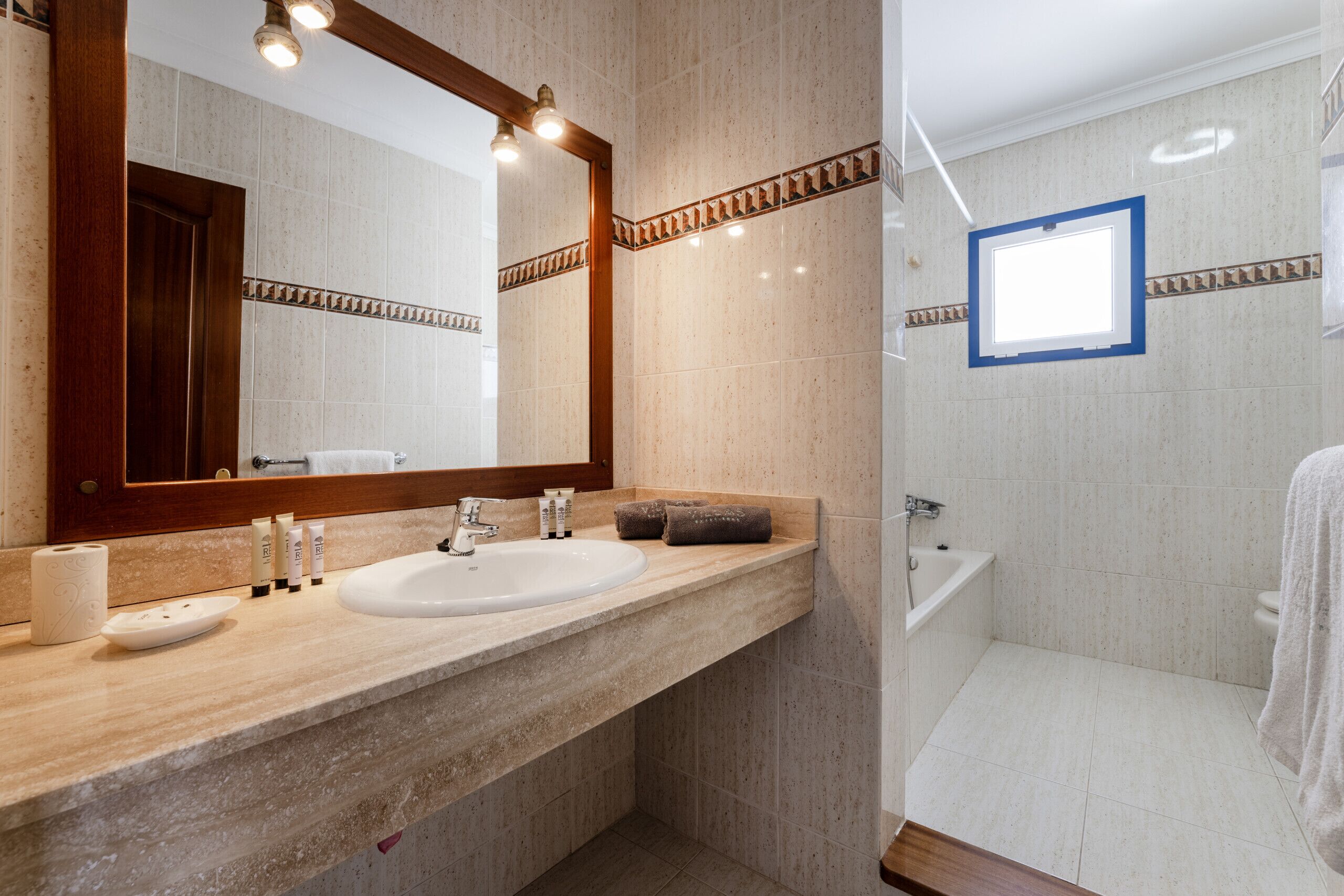 Een moderne badkamer met een grote spiegel, een wastafel en een bad.