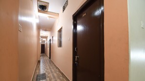 A hallway with a checkered floor, a door labeled "304", and a vent on the wall. - RADHA KRISHNA NIWAS (Puri)