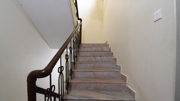 A staircase with marble steps and a wrought iron railing. - RADHA KRISHNA NIWAS (Puri)