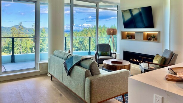 Een moderne woonkamer met een groot raam, een flatscreen televisie en een open haard.