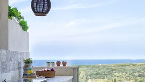 A kitchen with a view of the sea, potted plants, and a hanging lantern. - Stogu di Lusso by Interhome (Valledoria)
