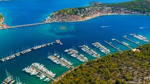 An aerial view of a coastal town with a marina filled with boats, surrounded by hills and a clear blue sea. - Vacation home Lynn by Interhome (Rogoznica)