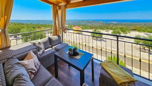 A balcony with a sofa, table, and potted plants. - Vacation home Lynn by Interhome (Rogoznica)