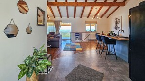 A spacious living area with a wooden ceiling, a kitchen with bar stools, and a dining area with a view. - Vacation home Lynn by Interhome (Rogoznica)