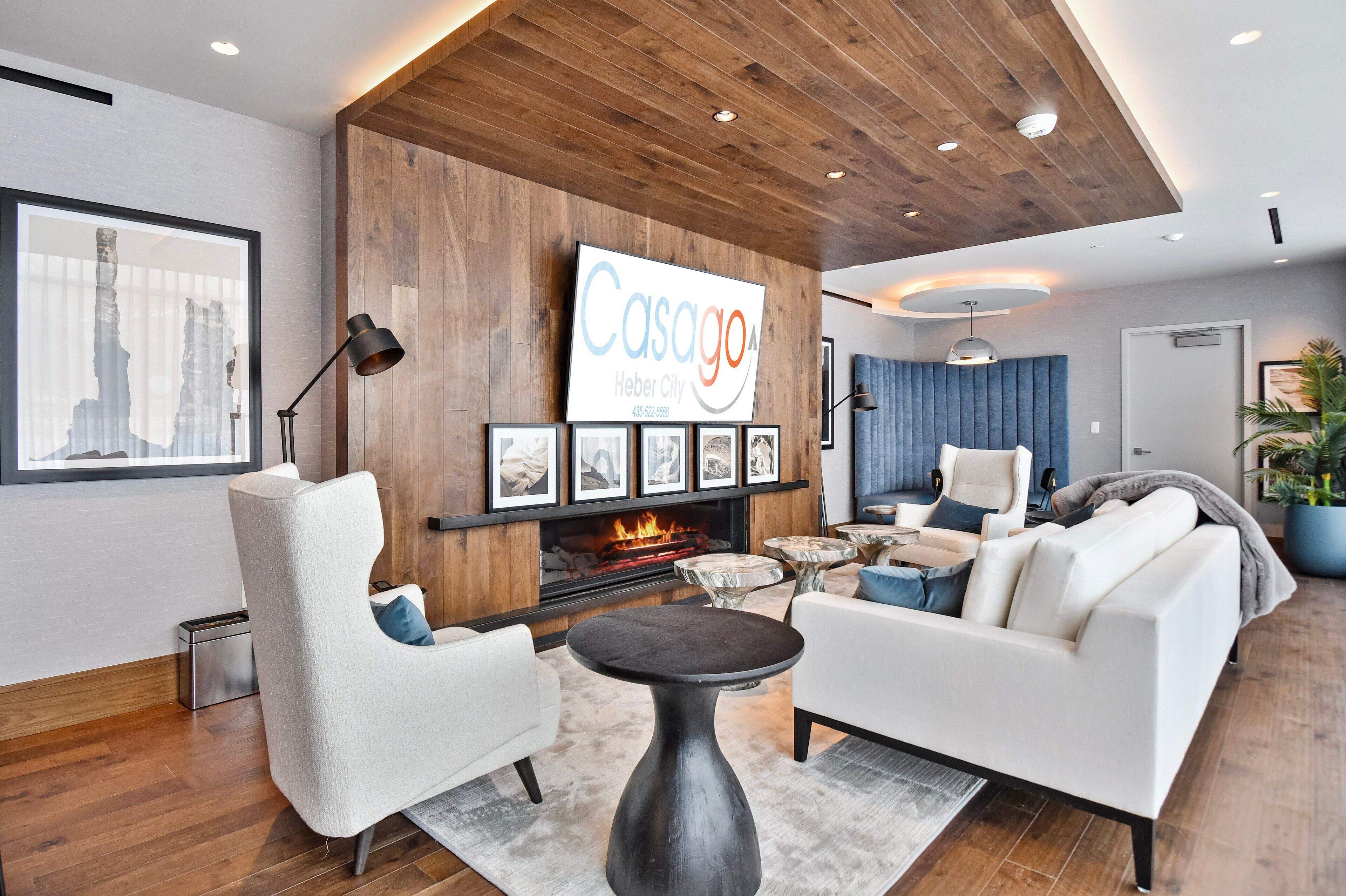 A modern living room with a fireplace, a mounted TV, and a wooden accent wall.