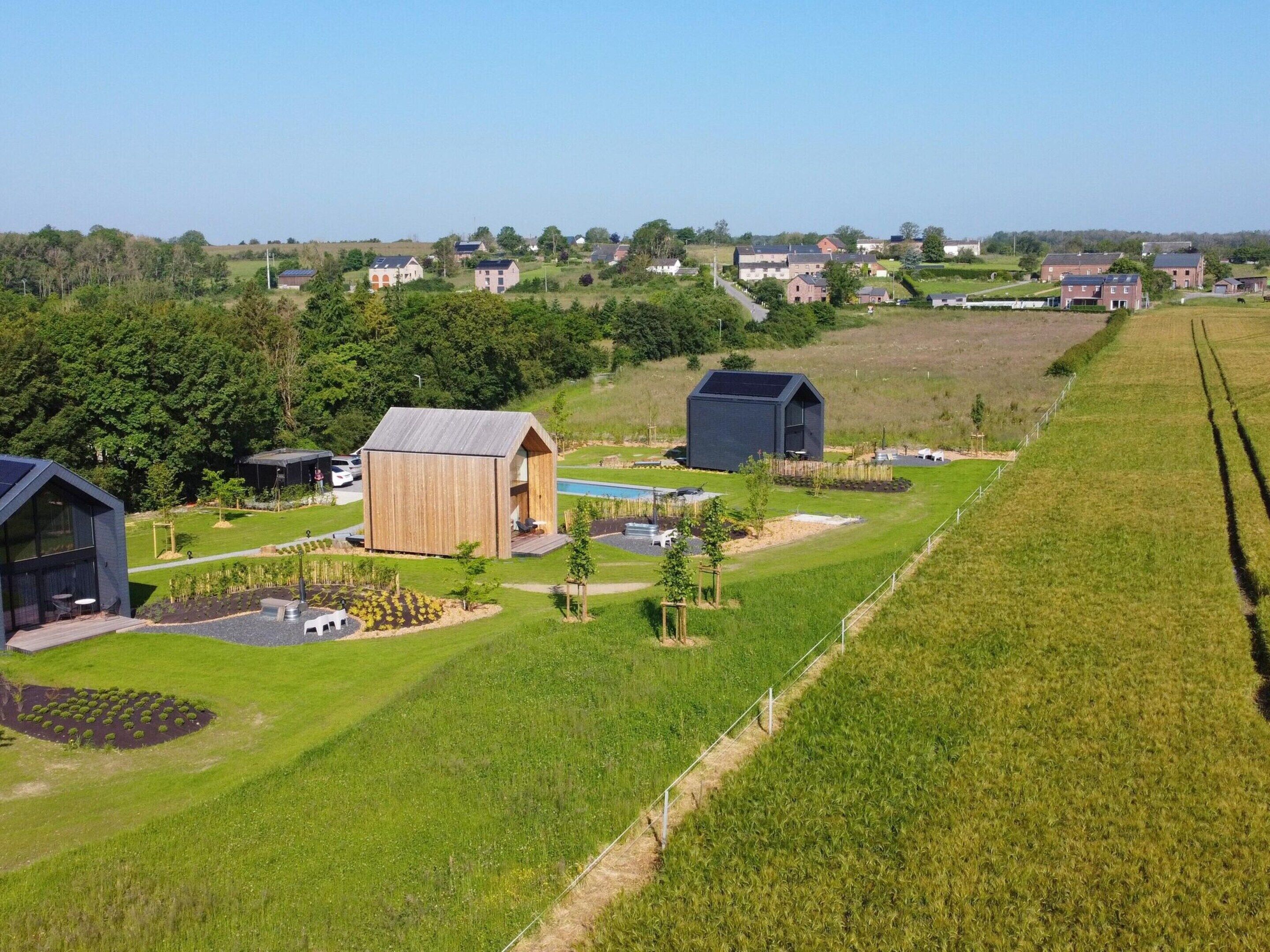 A rural property with a large barn, a smaller wooden structure, and a solar panel building.