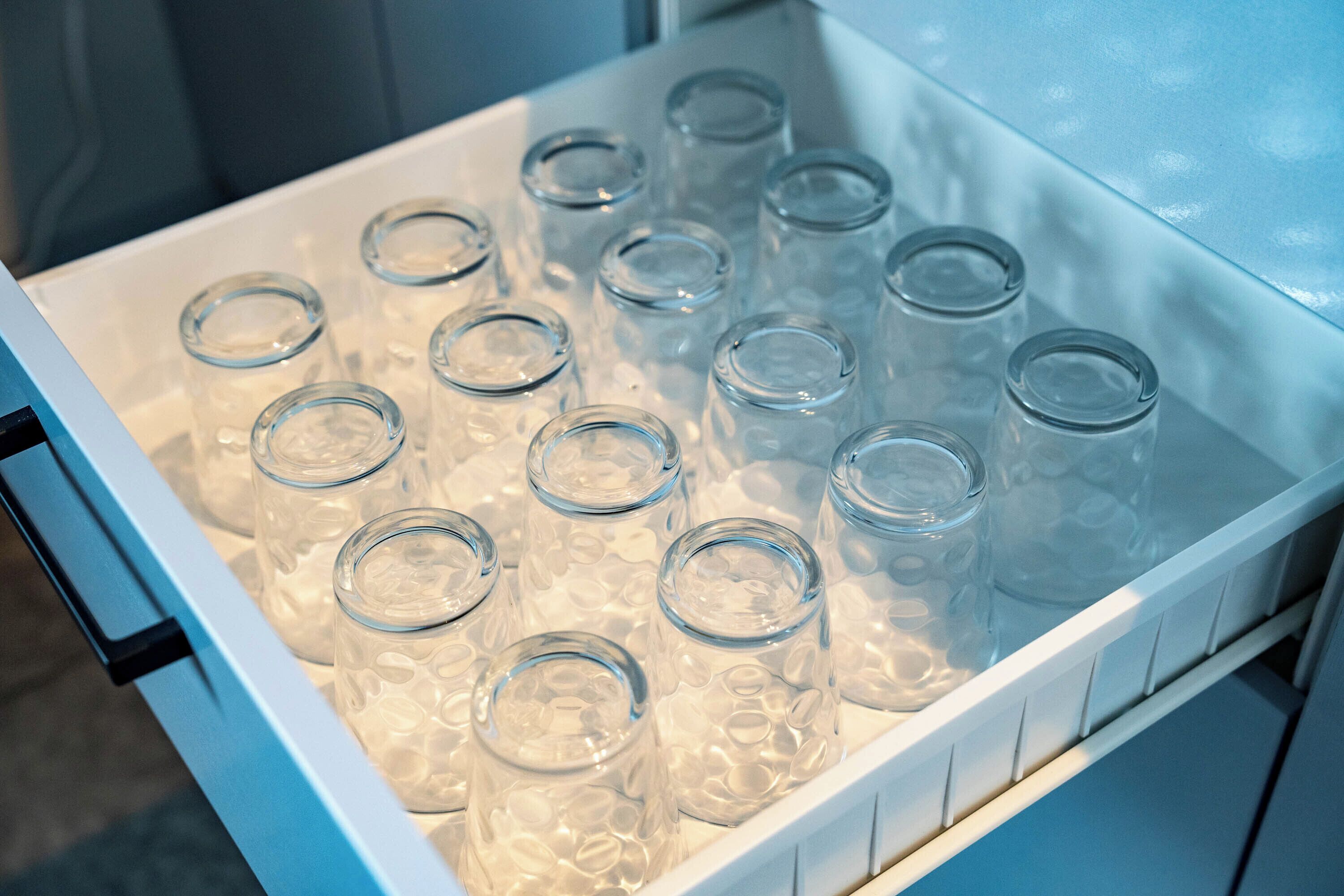 A refrigerator filled with clear glass bottles.