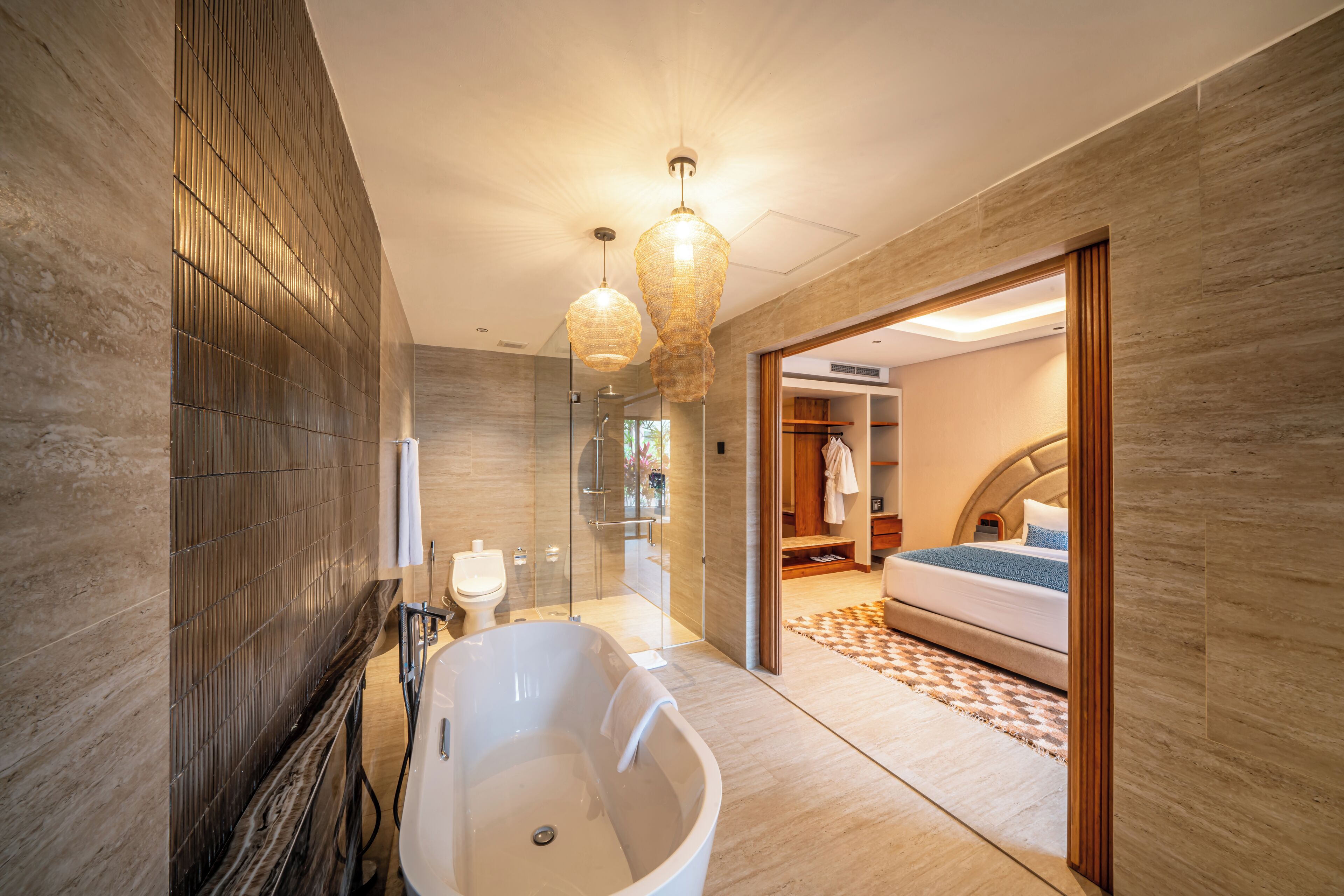 Un baño moderno con una bañera independiente, cabina de ducha con mampara de vidrio y vestidor.
