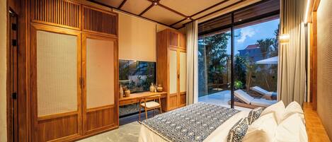 A bedroom with a large bed, wooden furniture, and a view of the outdoors.