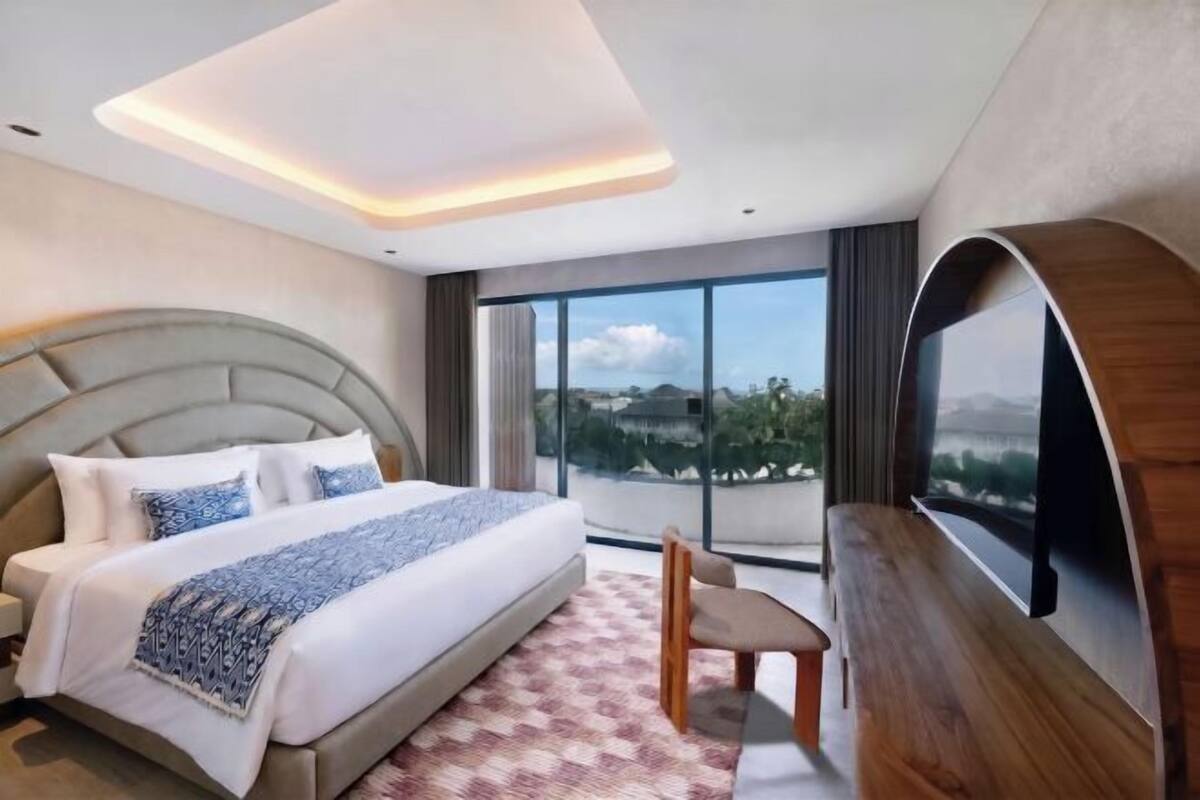 Une chambre d’hôtel moderne dotée d’un grand lit, d’une télévision et d’un balcon avec vue.