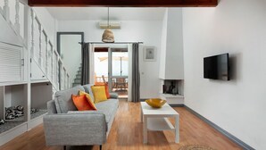 A modern living room with a grey sofa, a white coffee table, and a large window.