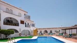 A two-story building with a swimming pool and outdoor seating area.