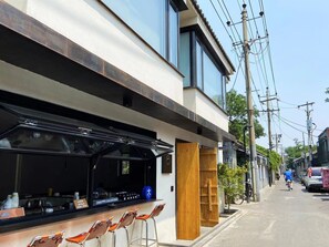 A modern building with a bar area, outdoor seating, and a sign indicating it is a specialty coffee shop. - (Beijing)