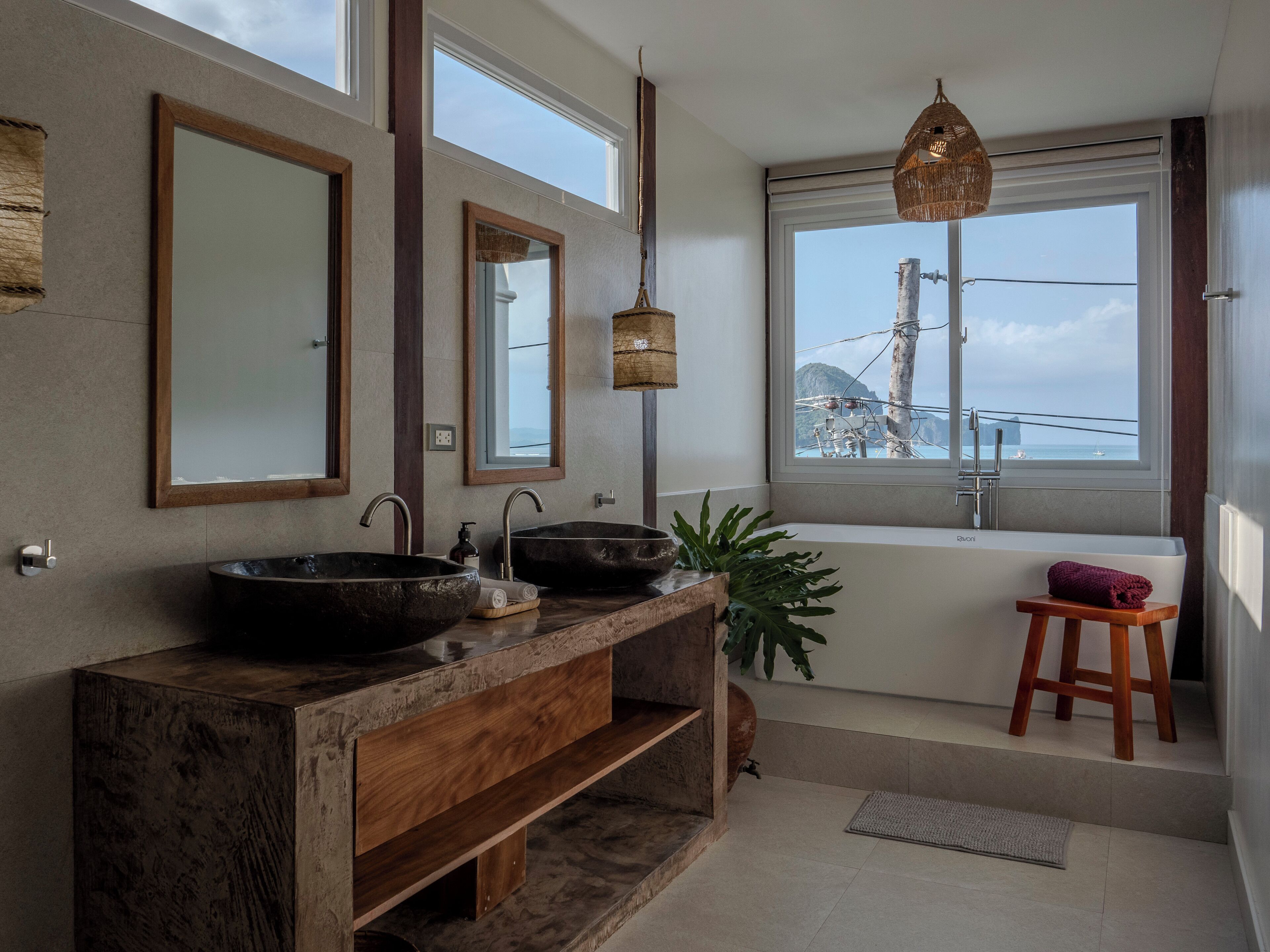 Une salle de bain moderne dotée d’une grande fenêtre, de deux vasques et d’un meuble-lavabo en bois.