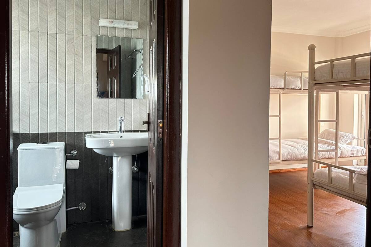 A bathroom with a toilet, sink, and mirror.
