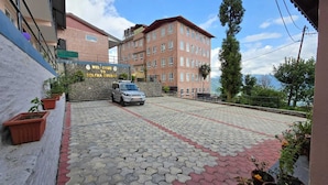 A paved driveway leading to a building with a sign reading "WELCOME TO DOLKHA DURBAR". - Hotel Dolkha Durbar (Bhimeshwar)