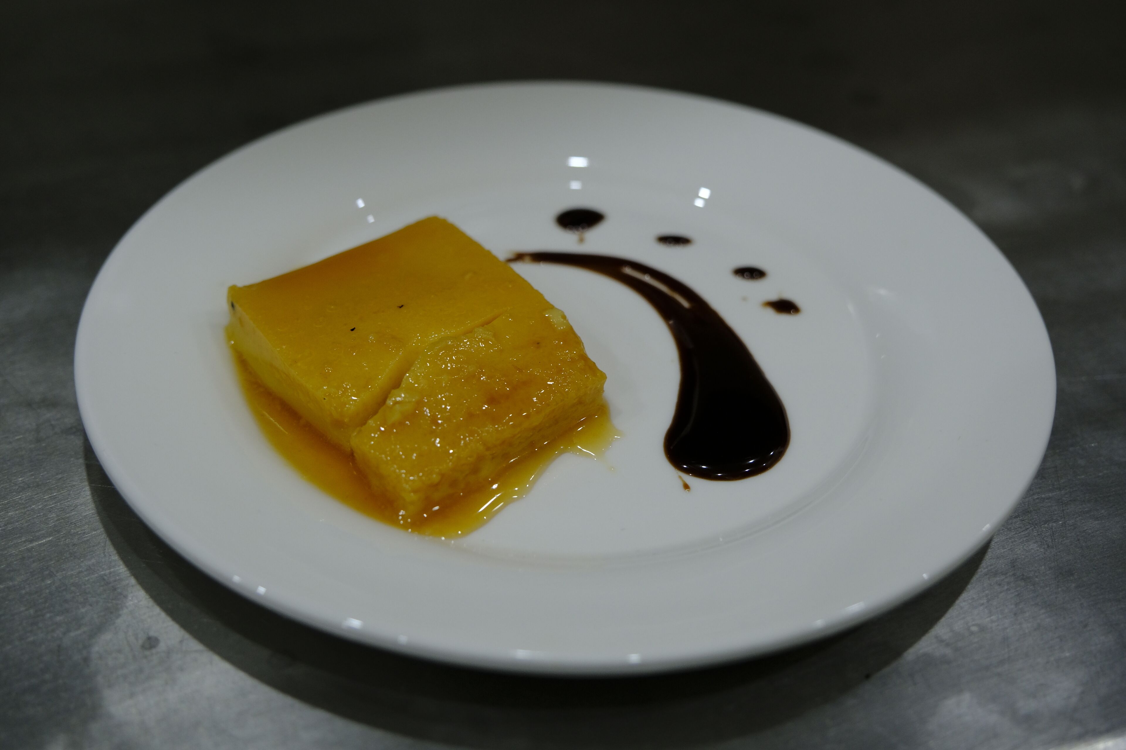 Un dessert su un piatto con un motivo decorativo a salsa.